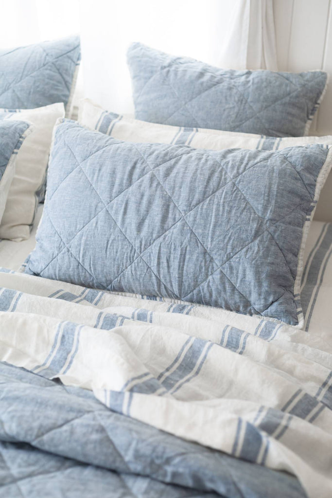 French Blue quilted shams styled on a coastal bed
