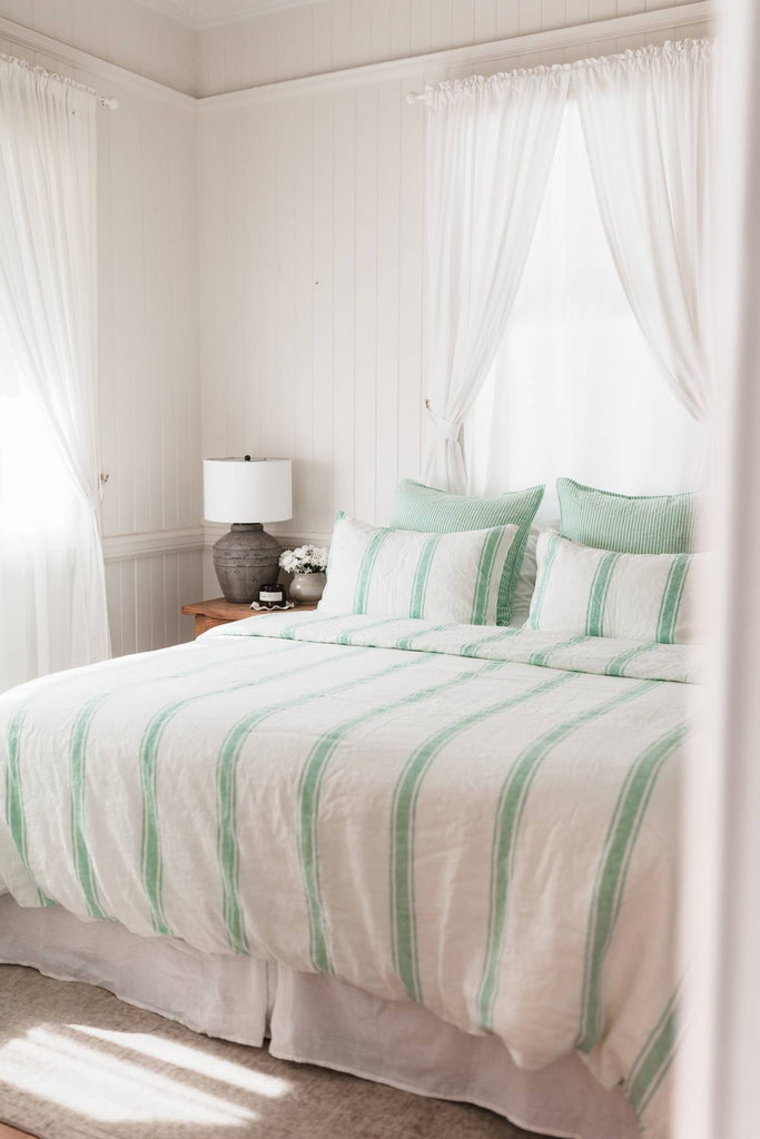 Bedroom with striped bedding and white curtains