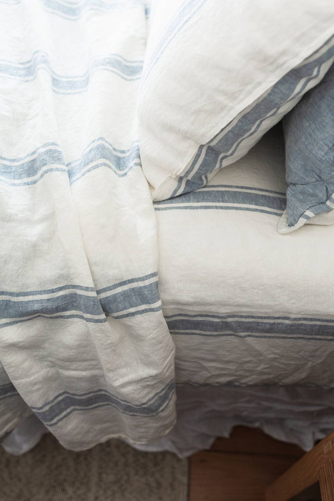 Close-up of striped bedding with a pillow on a bed.