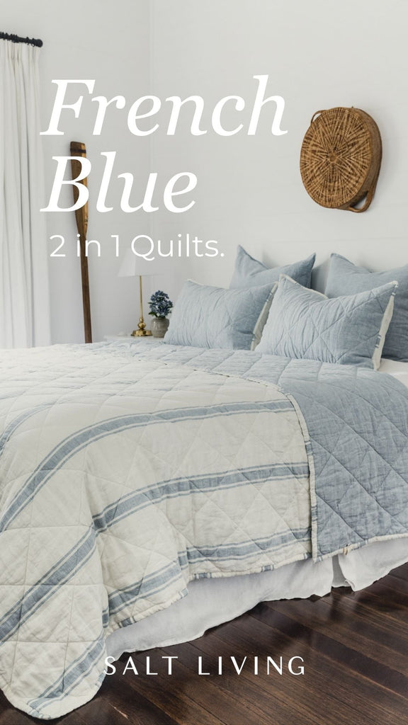 Bed with French Blue 2-in-1 quilts by Salt Living on a wooden floor.