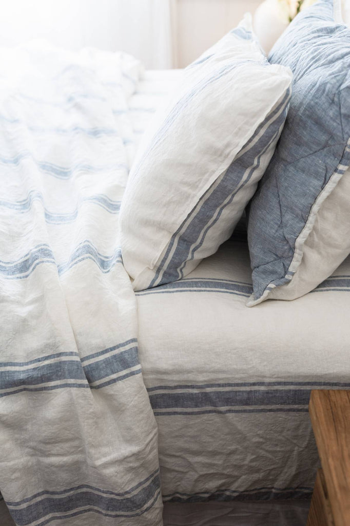 Close-up of a bed with blue and white striped bedding